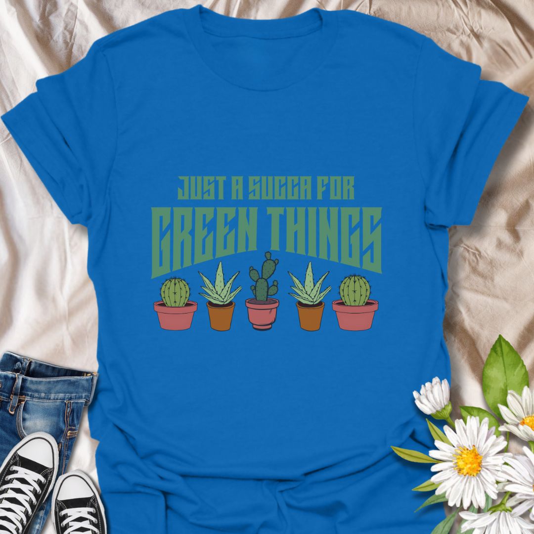 Embrace your love for all things leafy with this playful “Just a Succa for Green Things” t-shirt. Featuring a lineup of adorable potted succulents and bold retro typography, it’s perfect for plant lovers with a sense of humor.