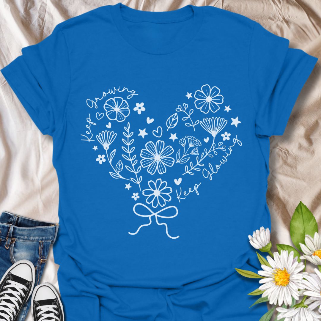 Charming floral heart t-shirt featuring delicate hand-drawn flowers with positive affirmations “Keep Growing, Keep Glowing.” A perfect uplifting gift for gardeners and plant lovers.  Royal blue