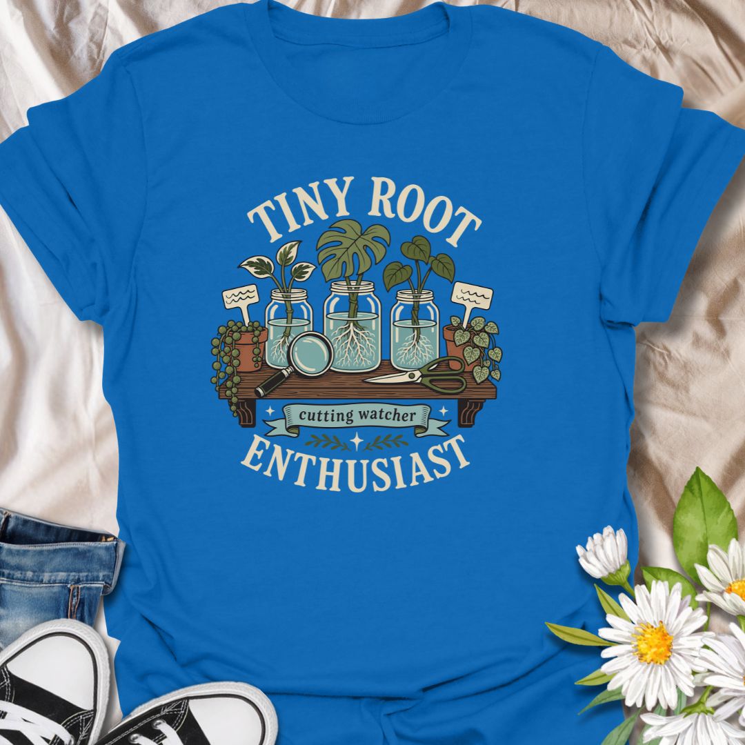 A playful propagation T-shirt for anyone fascinated by the first tiny roots appearing on a cutting. The design features glass jars, water-propagated plants, a magnifying glass, pruning shears, and trailing greenery. A thoughtful gift for houseplant lovers, propagation fans, and patient indoor gardeners.