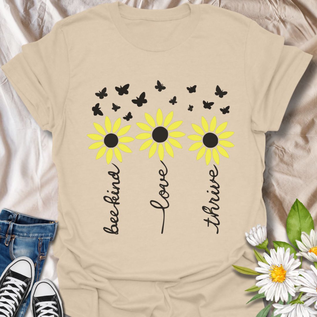 Inspire positivity with this uplifting floral graphic t-shirt featuring hand-lettered words be kind, love, thrive paired with charming daisies and fluttering butterflies. A perfect gift for flower lovers, kind souls, and anyone