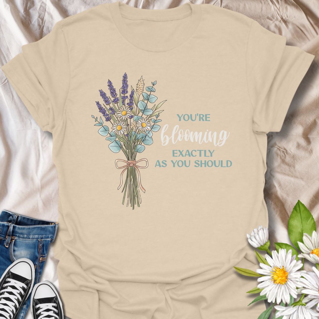 Celebrate growth and self-love with this elegant floral quote t-shirt. Featuring a beautifully illustrated bouquet and the inspiring words "You're blooming exactly as you should", this tee is perfect for anyone on a journey of personal growth. A thoughtful gift for plant lovers, teachers, mental health advocates, or anyone who appreciates uplifting messages in nature-inspired fashion.
