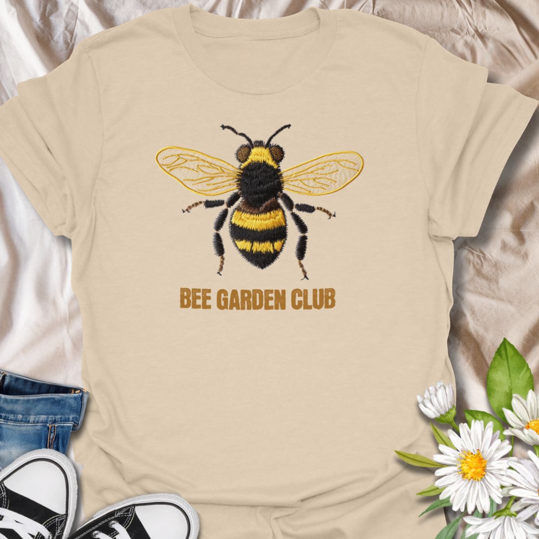 This Bee Garden Club t-shirt is made for gardeners, pollinator lovers, and nature fans who want a simple bee design with a refined botanical feel. Featuring a detailed faux-embroidered bee with golden wings, fuzzy black and yellow stripes, and clean Bee Garden Club lettering, this design has a classic garden-club look that is easy to wear. Perfect for bee lovers, gardeners, wildflower fans, pollinator supporters, nature lovers, and anyone who wants to celebrate the garden’s hardest little workers.