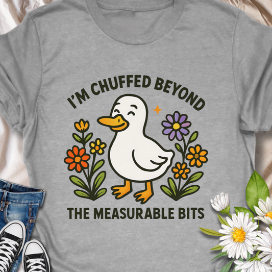 This adorable duck shirt with British slang makes a perfect gift for those who enjoy witty expressions and cheerful designs.
This adorable duck shirt carries a warm, goofy little joy: a happy duck nestled among hand-drawn flowers with the cheeky line “I’m chuffed beyond the measurable bits.” It reads like a tiny note of delight you’d wear on a sunny walk or while sharing a laugh with friends — it brings a quiet, everyday charm and a grin to anyone who spots that duck