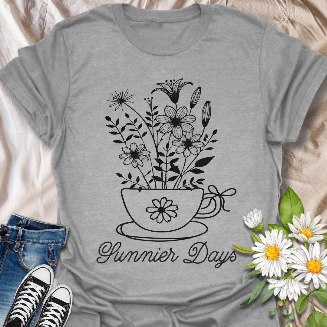 Charming floral t-shirt featuring hand-drawn white flowers blooming from a teacup with the words “Sunnier Days.” A cozy, uplifting design for flower lovers, tea drinkers, and anyone who embraces the simple joys of life. Great gift for gardeners and sunny souls.