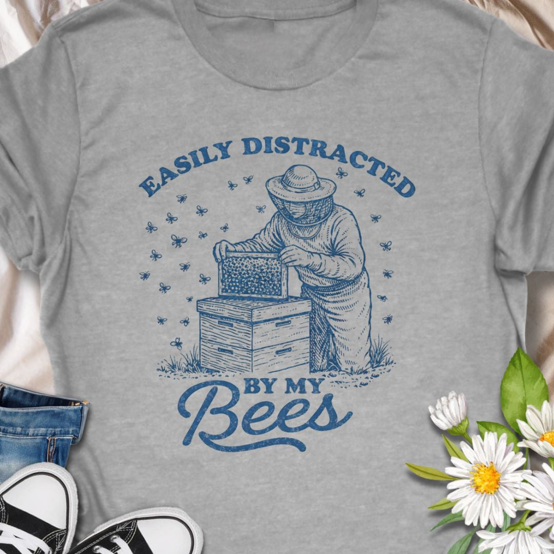 Show off your hive obsession with this “Easily Distracted By My Bees” t-shirt, featuring a vintage-style beekeeper and buzzing bees. Perfect gift for apiarists, backyard beekeepers, and bee lovers who’d rather be checking their hives than anything else.