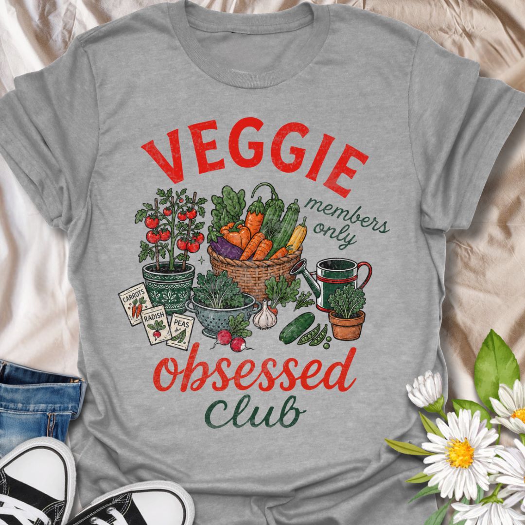 This Veggie Obsessed Club t-shirt is perfect for gardeners, vegetable lovers, and homegrown food fans. Featuring a colorful illustrated harvest scene with tomatoes, carrots, cucumbers, seed packets, and a watering can, this fun gardening tee is great for anyone who loves growing their own food and spending time in the garden.