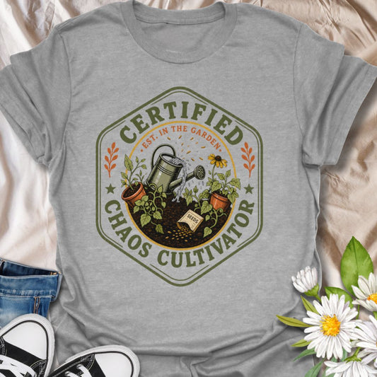 This Certified Chaos Cultivator t-shirt is made for gardeners who start with good intentions, then somehow end up surrounded by seed packets, soil, seedlings, and a very full watering can. The vintage badge-style design features garden tools, sprouting plants, terracotta pots, and playful botanical details for a funny but wearable gardening look. Perfect for plant lovers, backyard gardeners, allotment growers, chaotic gardeners, plant moms, homesteaders, and anyone who proudly grows a little beautiful chaos