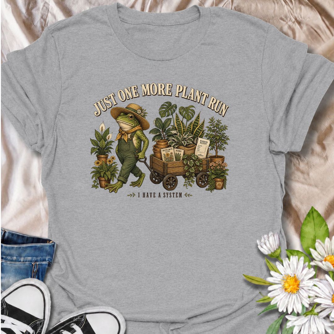 A funny plant-shopping T-shirt featuring a stylish frog and a wagon full of nursery finds. Made for plant lovers who can never buy just one more.