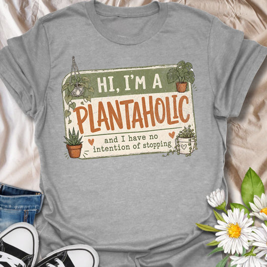 This Hi, I’m A Plantaholic t-shirt is perfect for plant lovers who can never resist one more houseplant. Featuring a playful badge-style layout with potted plants, trailing vines, and the phrase and I have no intention of stopping, this design brings a fun and relatable plant-parent vibe to any casual outfit. A great gift for plant moms, houseplant collectors, propagation fans, indoor gardeners, and anyone proudly obsessed with their growing plant collection.
