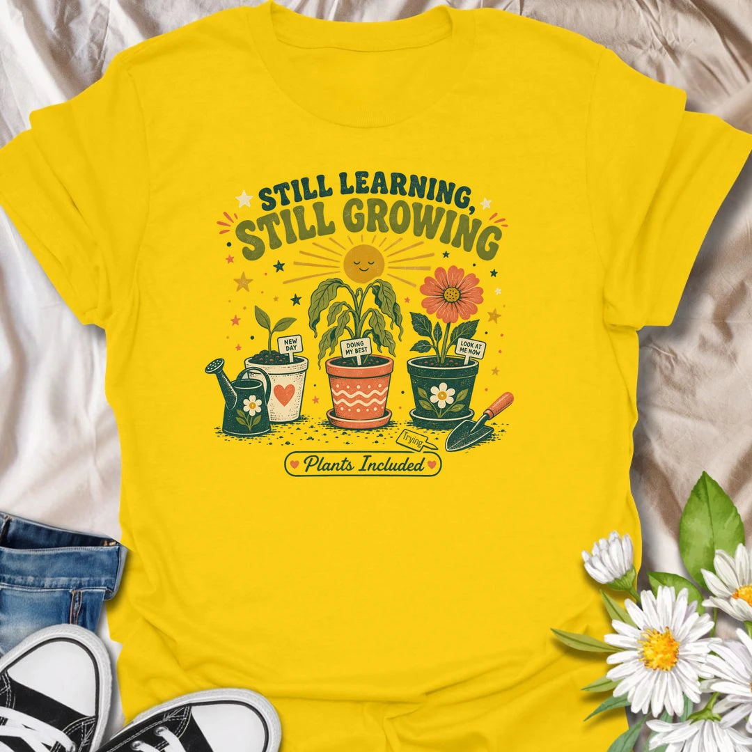 Encouraging plant t-shirt with cheerful garden pots, flowers, and a soft growth message for plant lovers and gardeners.