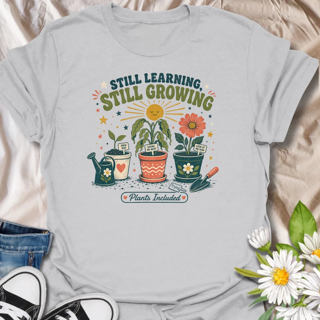 Encouraging plant t-shirt with cheerful garden pots, flowers, and a soft growth message for plant lovers and gardeners.