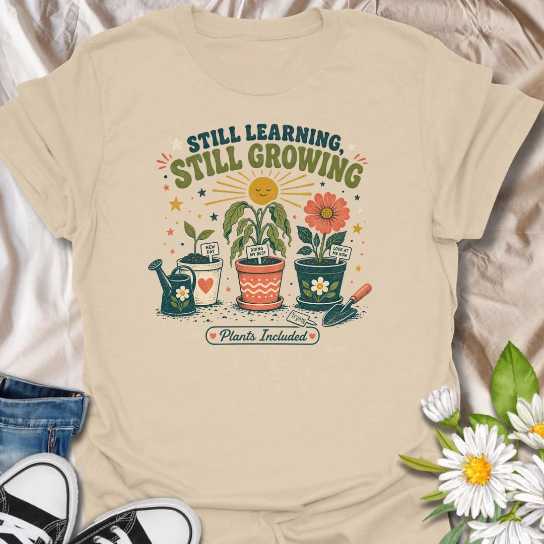 Encouraging plant t-shirt with cheerful garden pots, flowers, and a soft growth message for plant lovers and gardeners.