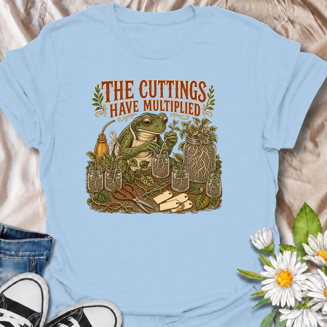 Celebrate a propagation collection that keeps growing with this funny “The Cuttings Have Multiplied” T-shirt. Featuring a charming frog surrounded by rooted plant cuttings, glass jars, scissors, and trailing vines, it is perfect for enthusiastic houseplant propagators. A playful gift for plant moms, pothos lovers, and anyone whose plant babies have taken over.