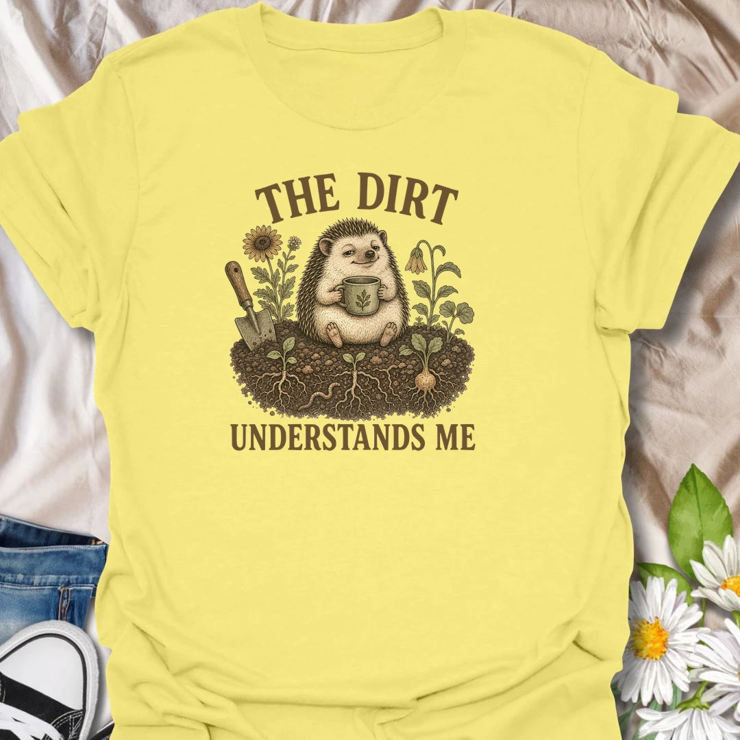This The Dirt Understands Me t-shirt is perfect for gardeners who feel most at home with soil, seedlings, flowers, and a warm drink nearby. Featuring a cozy hedgehog sitting in the garden with a mug, trowel, roots, blooms, and earthy botanical details, this design is great for plant lovers, backyard gardeners, cottage garden fans, nature lovers, and anyone who feels understood by the dirt.
