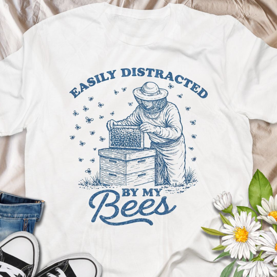 Show off your hive obsession with this “Easily Distracted By My Bees” t-shirt, featuring a vintage-style beekeeper and buzzing bees. Perfect gift for apiarists, backyard beekeepers, and bee lovers who’d rather be checking their hives than anything else.
