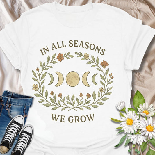 Celebrate growth and renewal with this celestial botanical t-shirt featuring moon phases, floral accents, and the inspirational message "In All Seasons We Grow." A perfect blend of nature, spirituality, and positivity for free spirits, moon lovers, and mindful living enthusiasts.