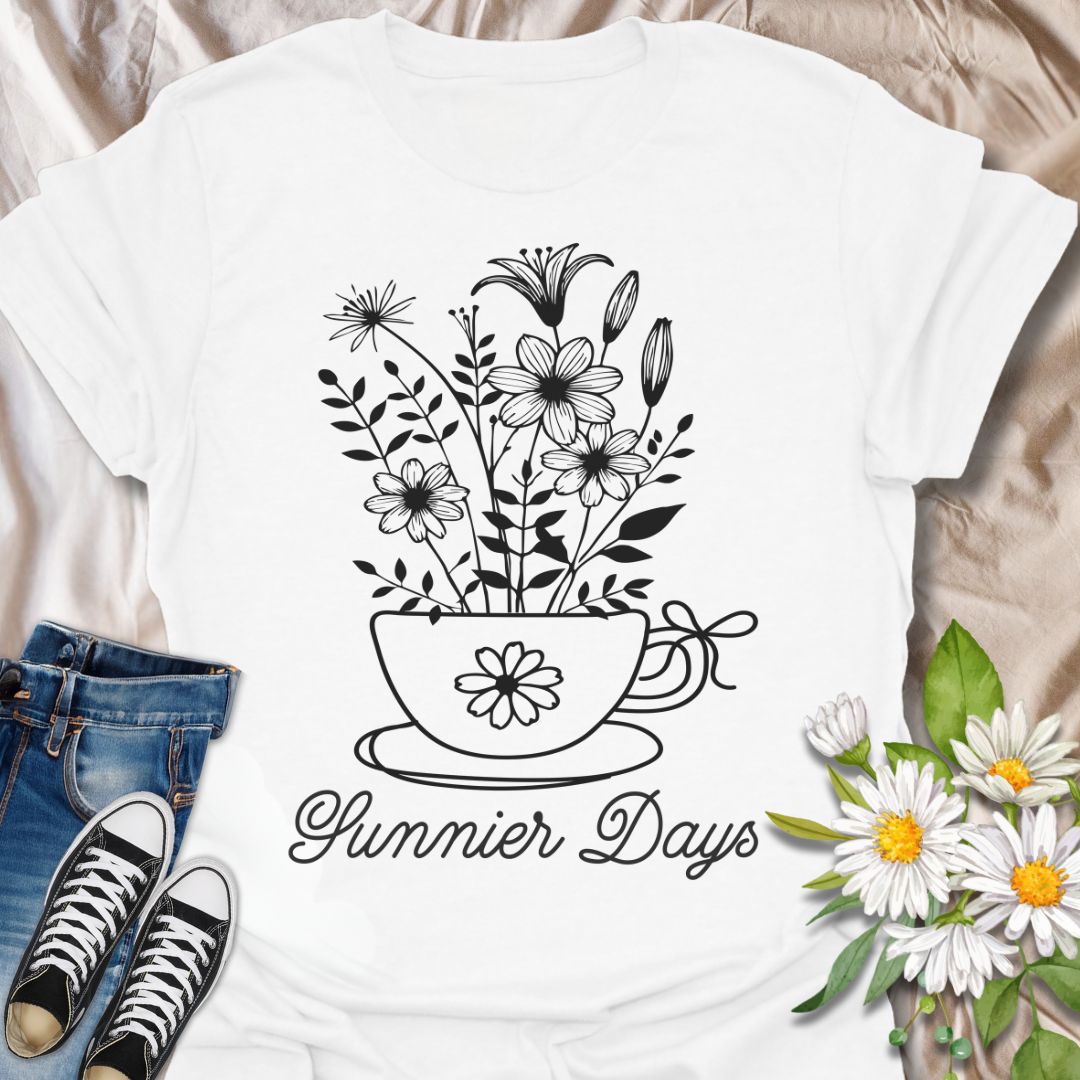 Charming floral t-shirt featuring hand-drawn white flowers blooming from a teacup with the words “Sunnier Days.” A cozy, uplifting design for flower lovers, tea drinkers, and anyone who embraces the simple joys of life. Great gift for gardeners and sunny souls.