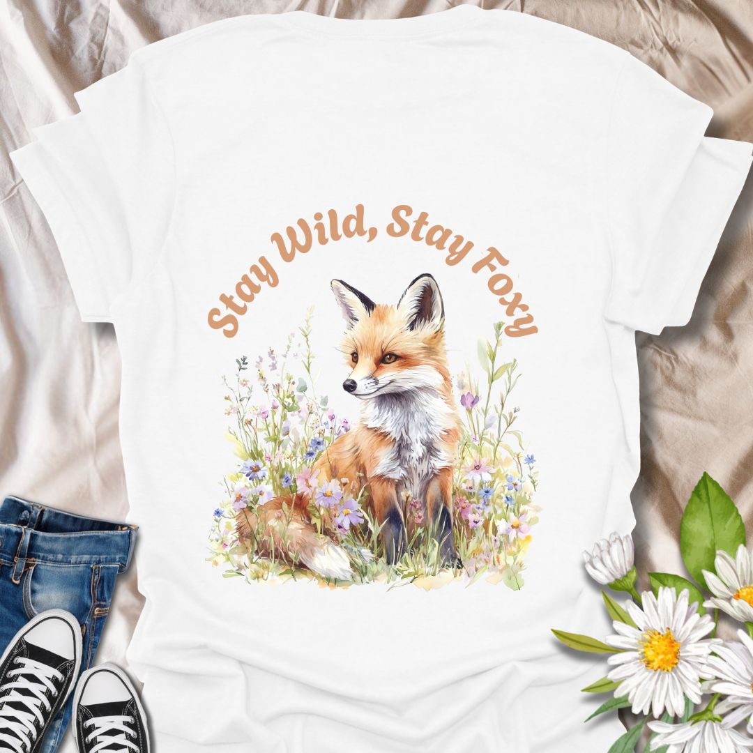 Charming t-shirt featuring a fox sitting among wildflowers with “Stay Wild, Stay Foxy” quote. Perfect gift for animal lovers, nature enthusiasts, and wildlife fans who adore foxes, woodland creatures, floral art, and playful outdoor vibes.