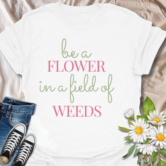 Stand out with this inspirational graphic t-shirt featuring the motivational phrase "Be a Flower in a Field of Weeds." Perfect for positivity seekers, nature lovers, and anyone who enjoys uplifting, floral-themed apparel with a meaningful message.