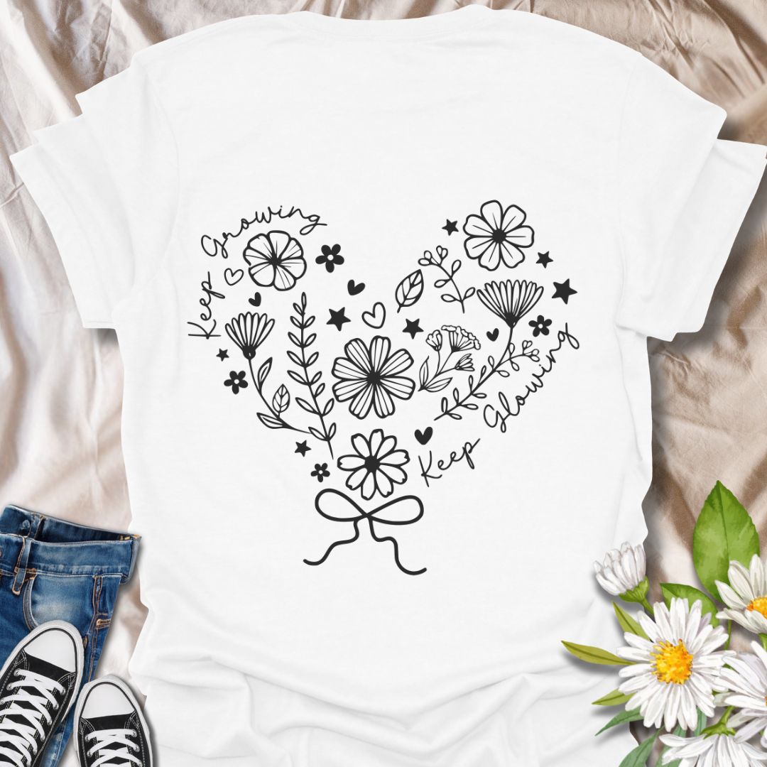 Charming floral heart t-shirt featuring delicate hand-drawn flowers with positive affirmations “Keep Growing, Keep Glowing.” A perfect uplifting gift for gardeners and plant lovers.  White