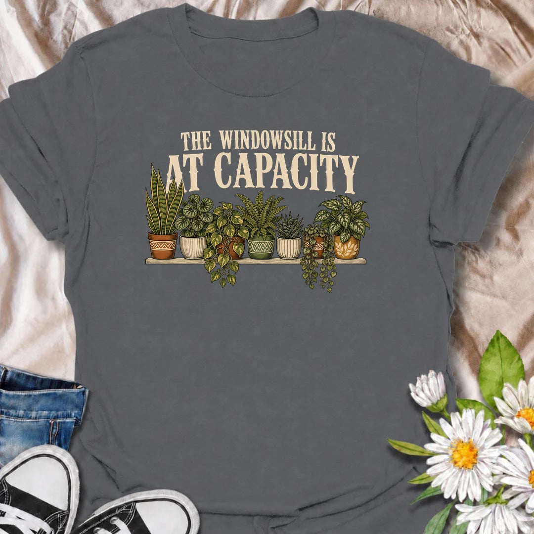 A funny houseplant T-shirt for anyone whose windowsill has officially run out of room. Featuring a packed row of potted houseplants, this design is perfect for plant parents, indoor gardeners, and collectors who keep finding space for just one more. The phrase “The Windowsill Is at Capacity” captures the reality of a growing indoor jungle with dry, relatable humor. It makes a great gift for pothos lovers, succulent fans, and anyone whose best window is permanently reserved for plants. Ideal for plant swaps,