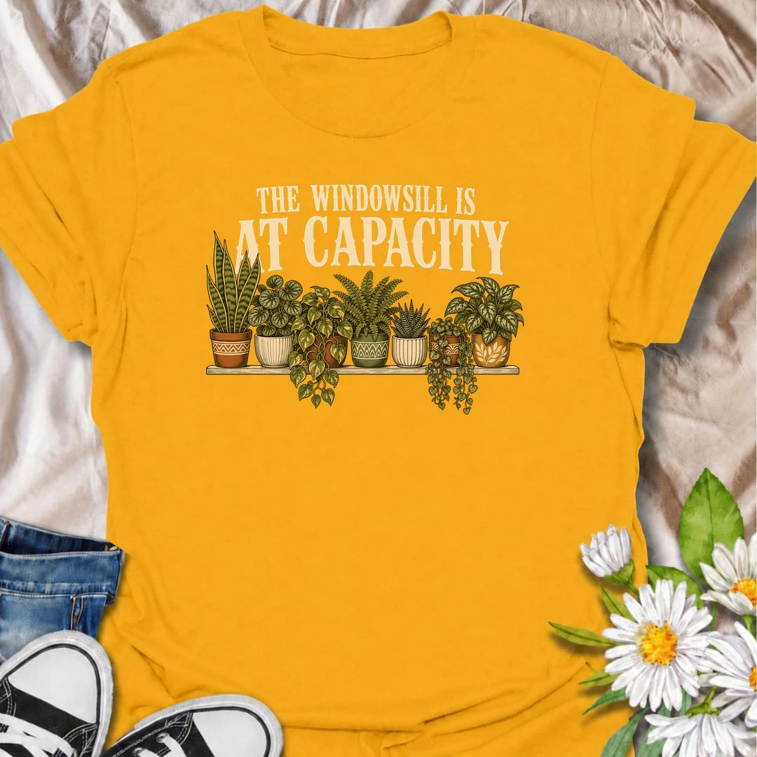 A funny houseplant T-shirt for anyone whose windowsill has officially run out of room. Featuring a packed row of potted houseplants, this design is perfect for plant parents, indoor gardeners, and collectors who keep finding space for just one more. The phrase “The Windowsill Is at Capacity” captures the reality of a growing indoor jungle with dry, relatable humor. It makes a great gift for pothos lovers, succulent fans, and anyone whose best window is permanently reserved for plants. Ideal for plant swaps,