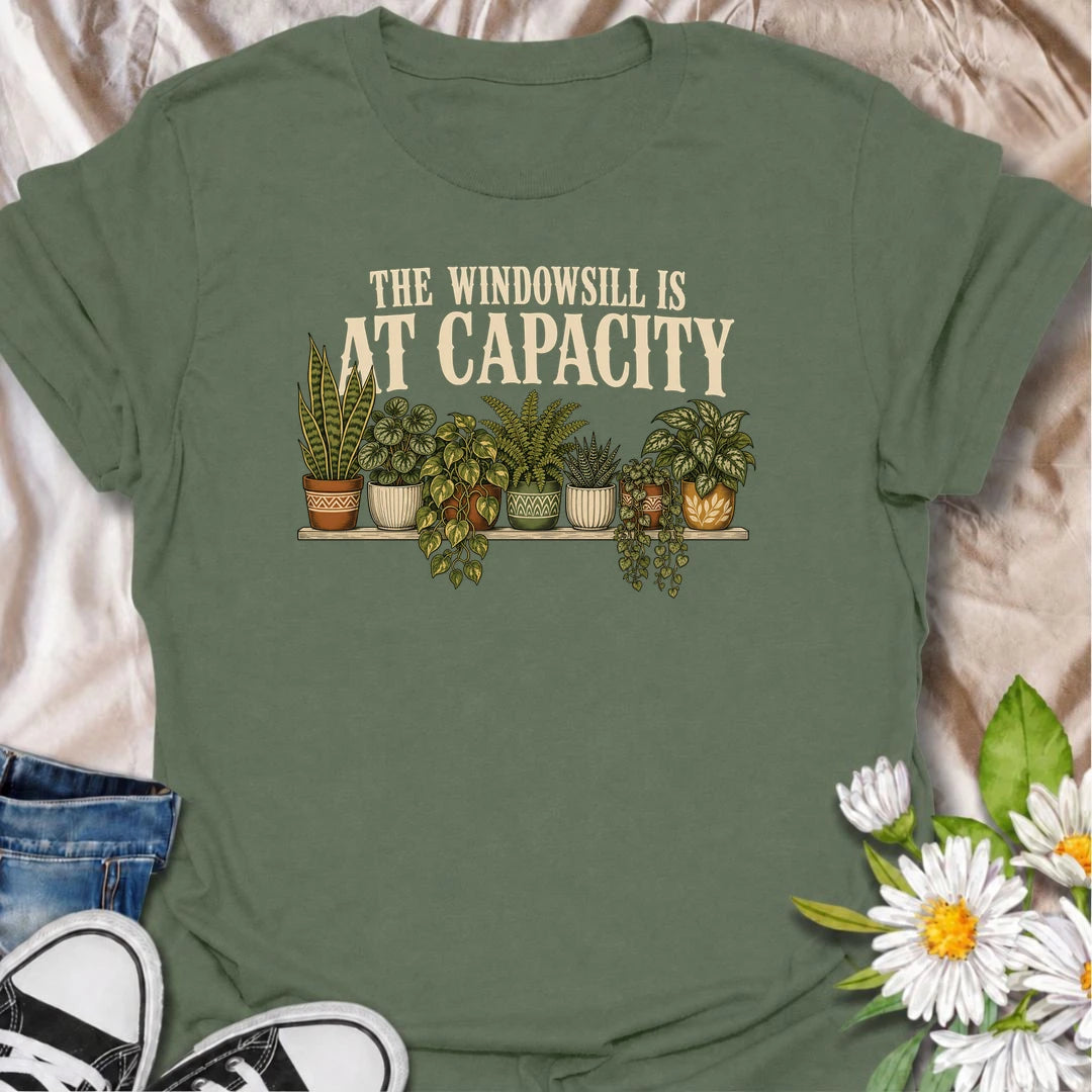 A funny houseplant T-shirt for anyone whose windowsill has officially run out of room. Featuring a packed row of potted houseplants, this design is perfect for plant parents, indoor gardeners, and collectors who keep finding space for just one more. The phrase “The Windowsill Is at Capacity” captures the reality of a growing indoor jungle with dry, relatable humor. It makes a great gift for pothos lovers, succulent fans, and anyone whose best window is permanently reserved for plants. Ideal for plant swaps,
