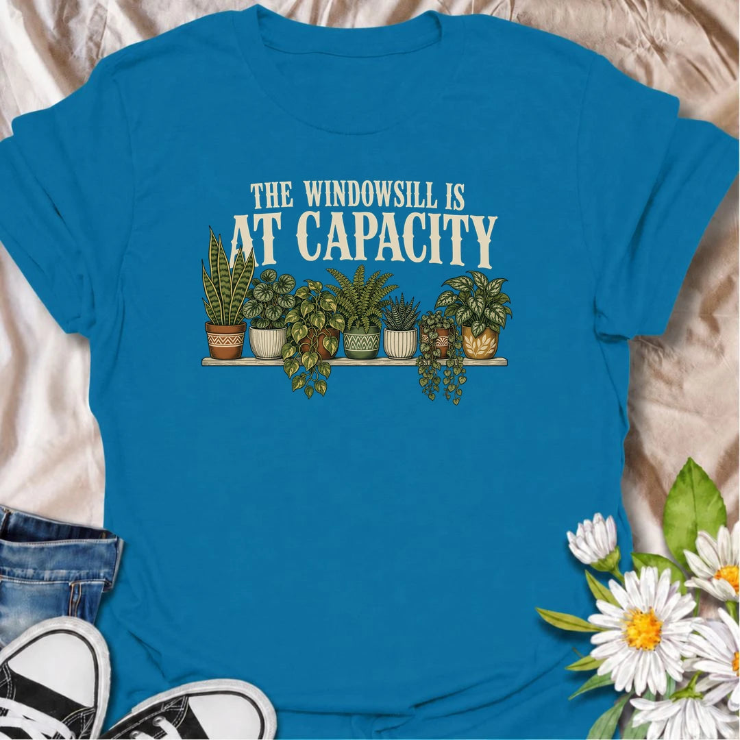 A funny houseplant T-shirt for anyone whose windowsill has officially run out of room. Featuring a packed row of potted houseplants, this design is perfect for plant parents, indoor gardeners, and collectors who keep finding space for just one more. The phrase “The Windowsill Is at Capacity” captures the reality of a growing indoor jungle with dry, relatable humor. It makes a great gift for pothos lovers, succulent fans, and anyone whose best window is permanently reserved for plants. Ideal for plant swaps,