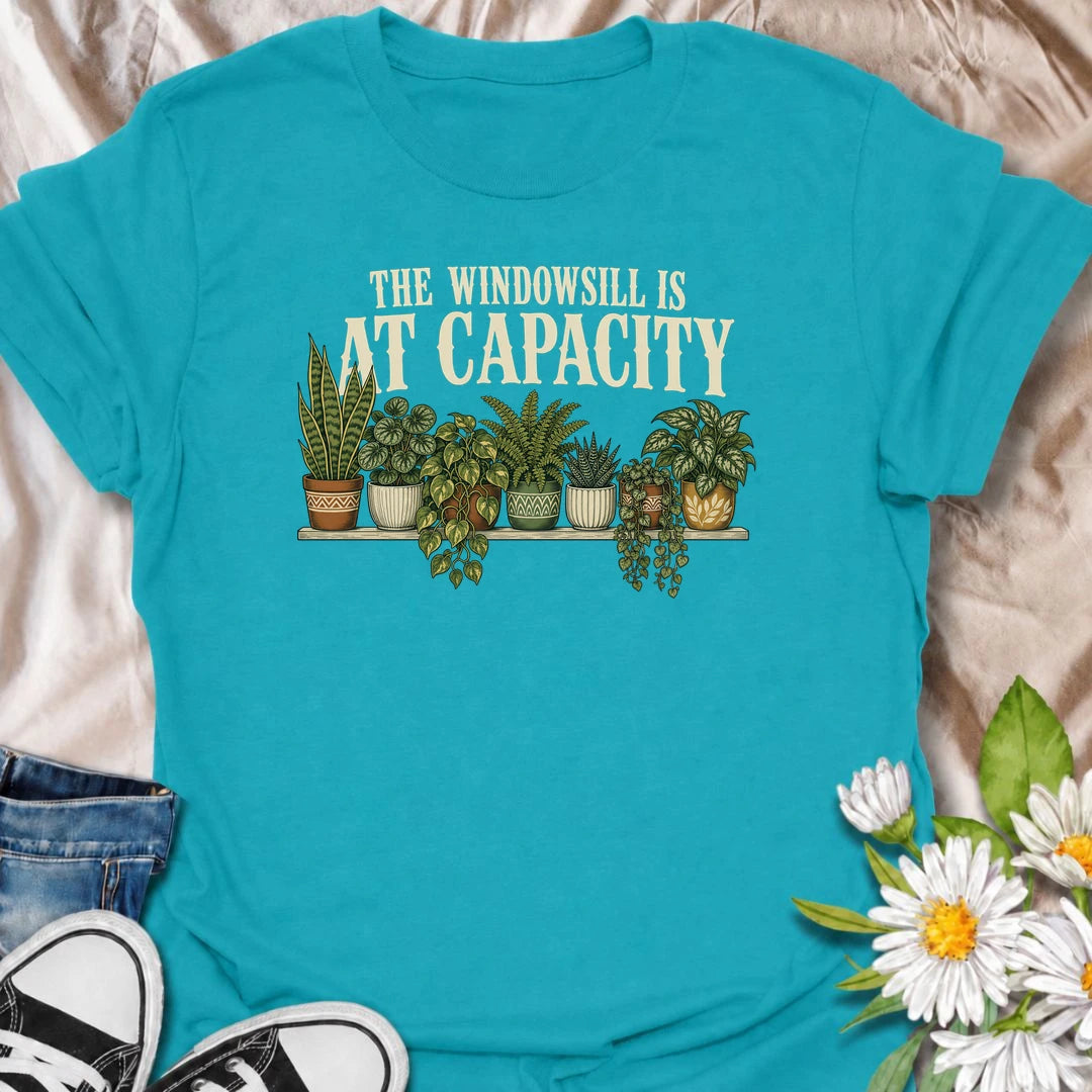 A funny houseplant T-shirt for anyone whose windowsill has officially run out of room. Featuring a packed row of potted houseplants, this design is perfect for plant parents, indoor gardeners, and collectors who keep finding space for just one more. The phrase “The Windowsill Is at Capacity” captures the reality of a growing indoor jungle with dry, relatable humor. It makes a great gift for pothos lovers, succulent fans, and anyone whose best window is permanently reserved for plants. Ideal for plant swaps,